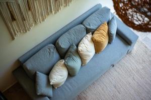 a blue couch with four pillows on it at Loft Hermosa at Tulum's Mistiq Temple II Beaches in Tulum