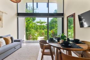 a living room with a table and a couch at Loft Hermosa at Tulum's Mistiq Temple II Beaches in Tulum