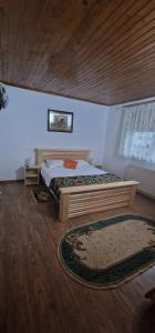 a bedroom with a bed and a wooden ceiling at Cabana Sebes Bera in Făgăraş