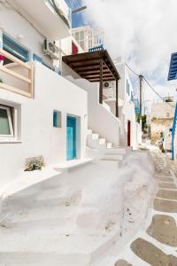 een wit gebouw met een trap en een blauwe deur bij Elenitas Studio in Mykonos Town in Mykonos-stad