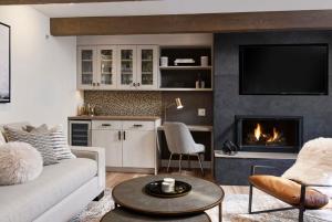 a living room with a couch and a fireplace at Fully Renovated 2 BR on River with Pool - Walk to Town! in Aspen