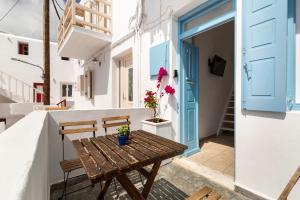 een houten tafel op een balkon met een blauwe deur bij Elenitas Studio in Mykonos Town in Mykonos-stad