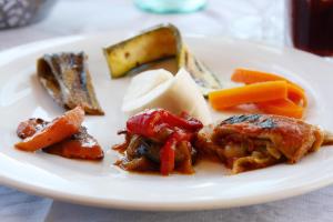 a plate of food with meat and vegetables on a table at Hotel La Certosa in Massa Lubrense