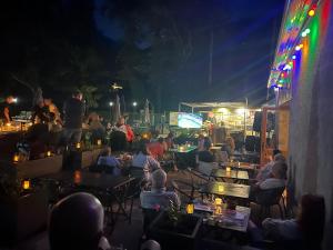 a crowd of people sitting at tables at night at Camping du Valentin in Laruns