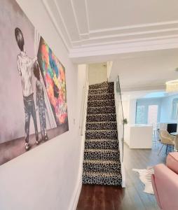 eine Treppe in einem Haus mit einem Gemälde an der Wand in der Unterkunft Brighton Cottage By The Sea in Brighton & Hove