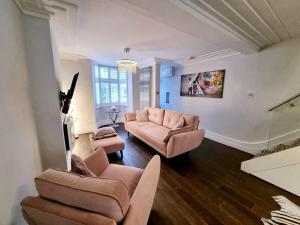 ein Wohnzimmer mit zwei Sofas und einem Fernseher in der Unterkunft Brighton Cottage By The Sea in Brighton & Hove