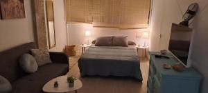 a living room with a bed and a couch at Apartamento acogedor El portil in El Portil
