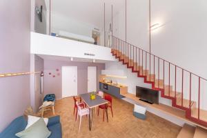 a living room with a staircase and a table and chairs at Hotel Piazza Bellini & Apartments in Naples