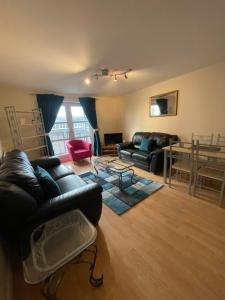 een woonkamer met een bank en een tafel bij Workers 3 bedroom beach boulevard apt in Aberdeen