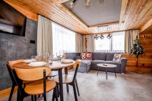 a dining room with a table and a couch at Apartament Hanka z Jacuzzi i widokiem na góry in Zakopane