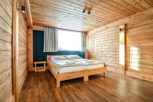 a bedroom with a bed in a wooden room at Apartament Hanka z Jacuzzi i widokiem na góry in Zakopane