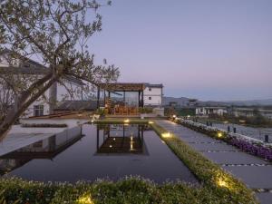 uma piscina de água com luzes em frente a um edifício em Dali Jiujing Inn em Dali
