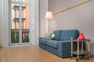 a blue couch in a living room with a window at Hotel Piazza Bellini & Apartments in Naples