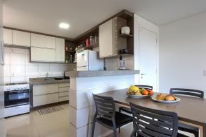 a kitchen with a table with a bowl of fruit on it at Breezes do cumbuco in Caucaia