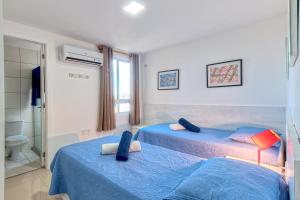 a bedroom with two beds with blue sheets at Breezes do cumbuco in Caucaia
