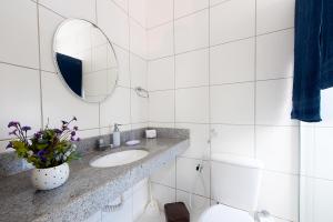 a white bathroom with a sink and a mirror at Breezes do cumbuco in Caucaia +12 photos