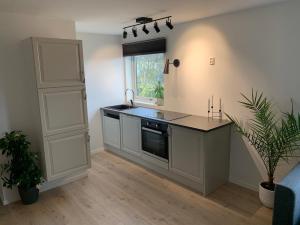 a kitchen with a counter and a sink and a window at Central and modern apartment in Hamar