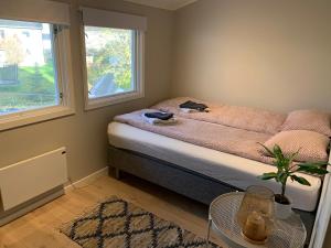a small bedroom with a bed and a window at Central and modern apartment in Hamar