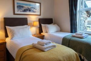 a bedroom with two beds with towels on them at Holmdale - Central Ambleside in Ambleside