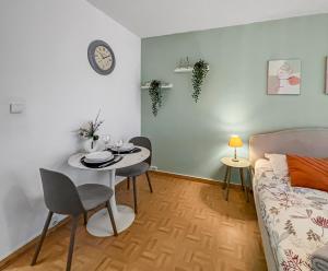 ein Wohnzimmer mit Tisch und Bett in der Unterkunft Cozy Balcon près de la Marne in Saint-Maur-des-Fossés + 13 Fotos