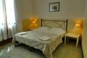 a bedroom with a bed with two tables and two lamps at Casa Vista Mare in Bosa