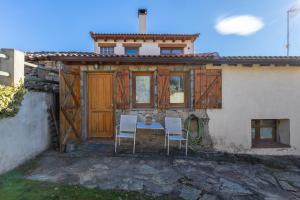 un tavolo e due sedie di fronte a una casa di Casa del Tio Primitivo a Navarredonda de Gredos