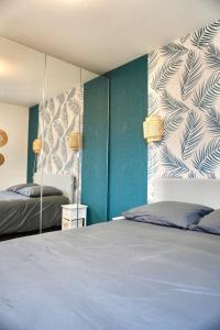 Un dormitorio con dos camas y una pared azul. en Le FOCH, appartement 3 chambres - proche Nancy Thermal, en Villers-lès-Nancy