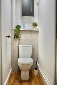 Un baño con inodoro con plantas en la pared. en Le FOCH, appartement 3 chambres - proche Nancy Thermal, en Villers-lès-Nancy 16 fotos más