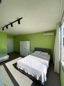 a bedroom with a large white bed and green walls at Sıla pansiyon in Gümbet