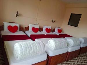 a room with three beds with red hearts on them at Sauraha Inn in Sauraha