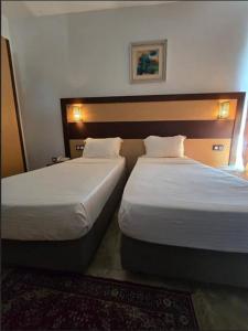 2 letti posti uno accanto all'altro in una camera d'albergo di Telemly Hotel a LʼAgha Altre 3 foto