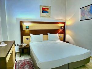 a bedroom with a large bed and a desk at Telemly Hotel in LʼAgha
