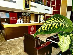 a lobby with a counter and a plant in a store at Telemly Hotel in LʼAgha