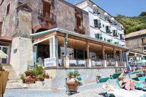 a building with people sitting in chairs in front of it at Hotel La Certosa in Massa Lubrense