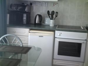 una cocina con estufa y encimera en Be my guest, en Hemborough Post