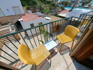 two chairs and a table on a balcony at Hostal Playa in Cala Santanyi