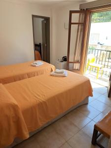 two beds in a room with a balcony at Hostal Playa in Cala Santanyi