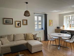 a living room with a couch and a table at Appartement duplex centre historique in Trévoux