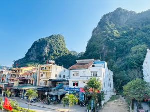 a group of buildings in front of a mountain at Palm Lodge in Bố Trạch