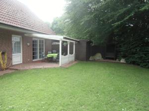 einen Hinterhof eines Hauses mit einem Rasenplatz in der Unterkunft Busche RE03 in Sögel