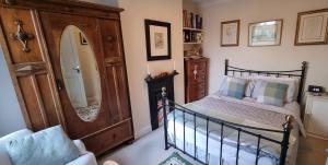 a bedroom with a bed and a large mirror at Quirky Victorian three bedroom terraced house in Eastleigh