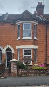 a red brick house with a window on it at Quirky Victorian three bedroom terraced house in Eastleigh
