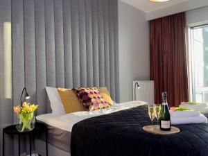 1 dormitorio con 1 cama y 1 mesa con copas de vino en URBAN APARTMENTS GLOBAL SKYLINE 18th Floor No 02 Free Garage, Self Check-in, No Deposit, en Katowice
