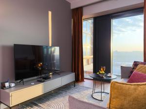 sala de estar con TV y ventana grande en URBAN APARTMENTS GLOBAL SKYLINE 18th Floor No 02 Free Garage, Self Check-in, No Deposit, en Katowice