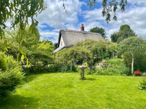 a cottage in a garden with a grass yard at Tawny Owl Barn in Craven Arms
