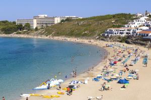 a group of people on a beach in the water at Apartamento CASTELLSOL 201 by Mauter Villas in Arenal d'en Castell