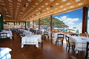 a restaurant with tables and chairs with a view of the ocean at Hotel La Certosa in Massa Lubrense