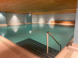 a large swimming pool with a ramp in a building at SuperG apartment in St. Moritz