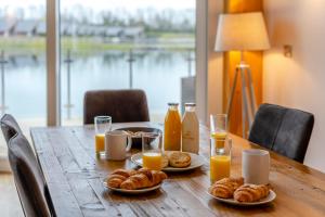 a table with plates of food and glasses of orange juice at Landal Twin Lakes in Carnforth