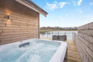 a bath tub sitting next to a wooden wall at Landal Twin Lakes in Carnforth